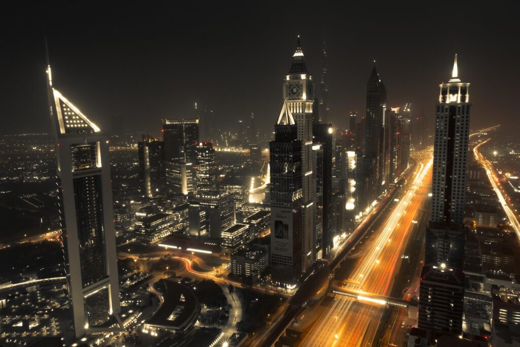 Night view of Dubai’s Sheikh Zayed Road with high-rise hotels and metro line access